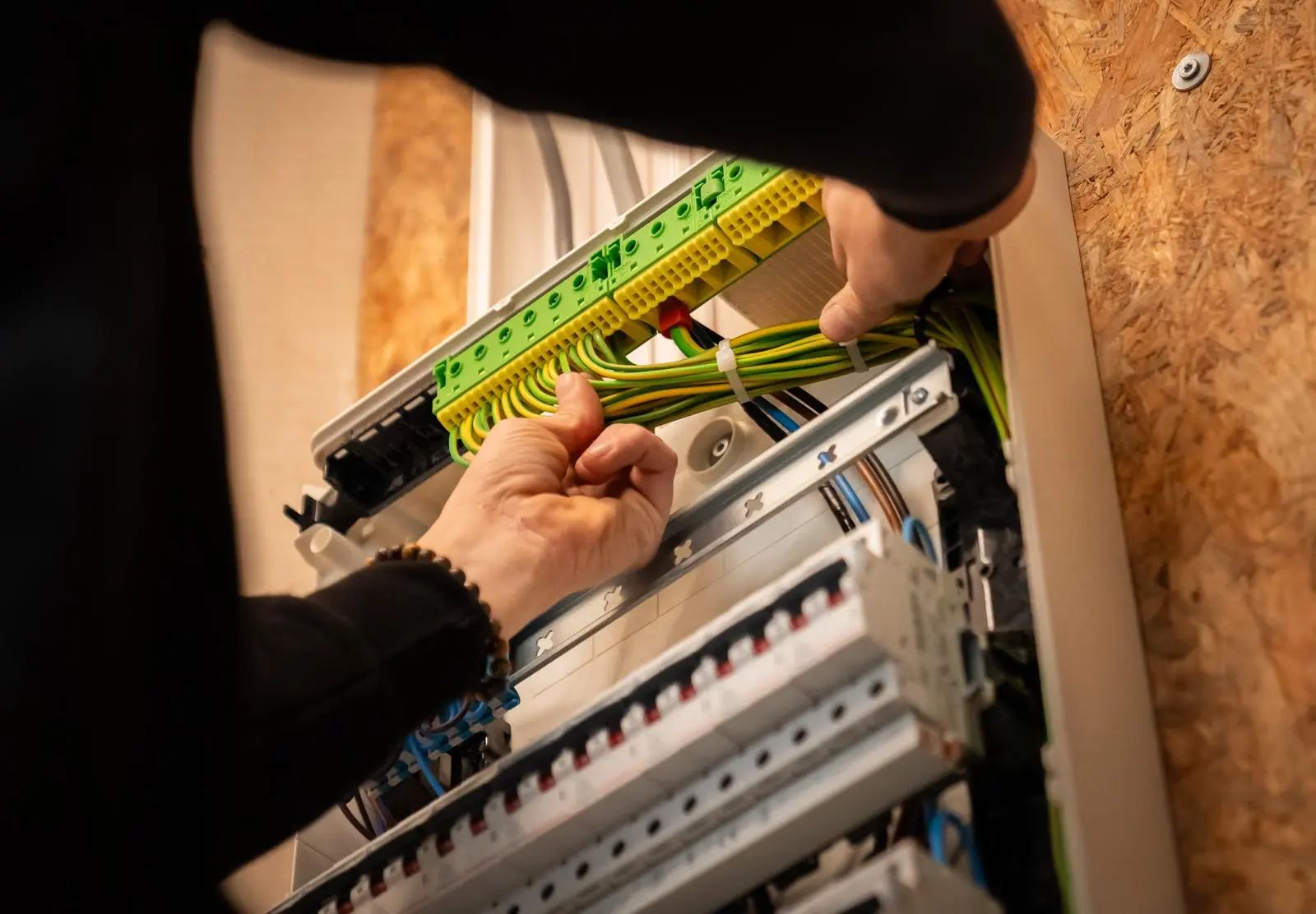 Erkende elektricien van ElektriciteitConform aan het werk aan een veilig en AREI-conform verdeelbord (zekeringkast)